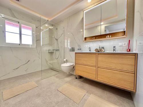a bathroom with a shower and a toilet and a sink at Sunset Apartment 6 & Heated Pool in Los Cristianos