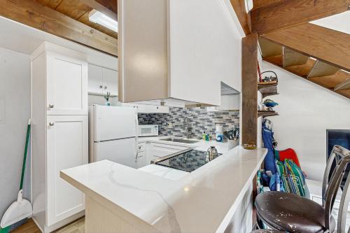 a kitchen with white cabinets and a white refrigerator at Sugar Shack in Carpinteria