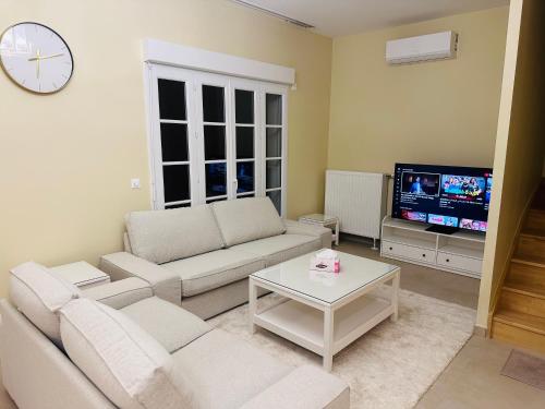 un salon avec un canapé et une télévision dans l'établissement Family's house - Villa proche de la vallée village et Disneyland paris ,2 parkings, air condition, à Serris