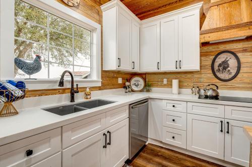 a kitchen with white cabinets and a chicken on the window at Furnished Deck and Views Rural Schulenburg Retreat in Schulenburg