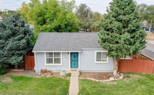 a white house with a blue door and a tree at Great two bedroom family spot with convenient access to downtown in Denver