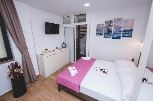 1 dormitorio con 1 cama con manta rosa en Apartment Felix, en Split