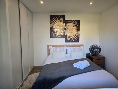 - une chambre avec un grand lit et une photo sur le mur dans l'établissement Charmante maisonnette individuelle avec jardin et terrasse, à Gargenville