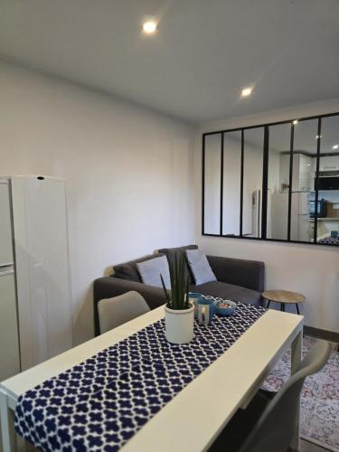 - un salon avec une table et une plante dans l'établissement Charmante maisonnette individuelle avec jardin et terrasse, à Gargenville