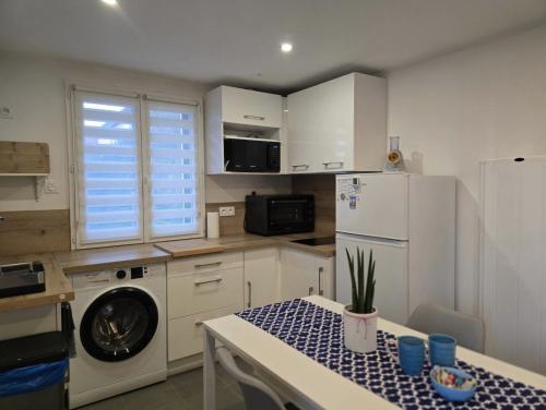 une petite cuisine avec une table et un réfrigérateur dans l'établissement Charmante maisonnette individuelle avec jardin et terrasse, à Gargenville