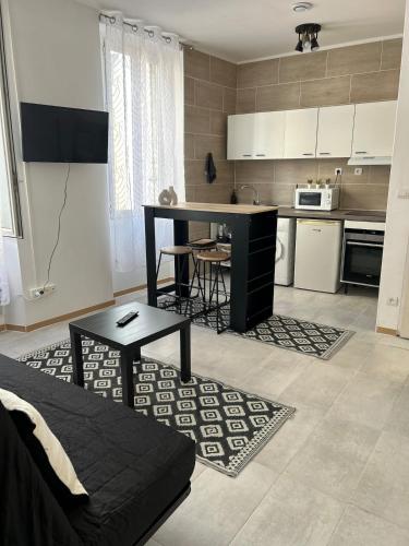 un salon avec une table et une cuisine dans l'établissement T2 cosy, à Marseille