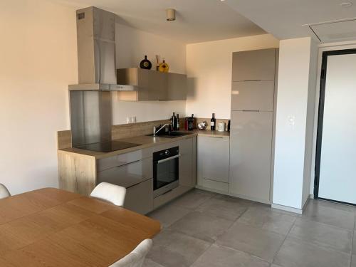 une cuisine avec des appareils en acier inoxydable et une table en bois dans l'établissement Superbe T2 avec terrasse, à Bastia