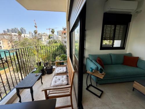 a living room with a couch and a balcony at Lovely 1-bedroom apartment in The best location in Tel Aviv