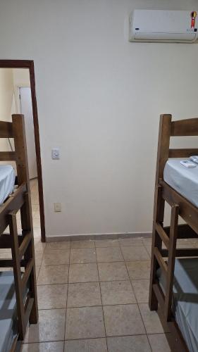 a room with two bunk beds and a white wall at Casa mobiliada para até 14 pessoas in Ribeirão Preto