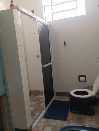 a bathroom with a toilet with a glass shower stall at Quartos para alugar em itu Hostel Jm in Itu