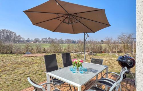 a table with a large umbrella on a patio at 2 Bedroom Nice Home In Zerpenschleuse in Zerpenschleuse