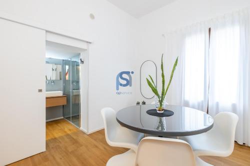 a dining room with a glass table and white chairs at Ni Ni Apartments - Self Check in in Cefalù