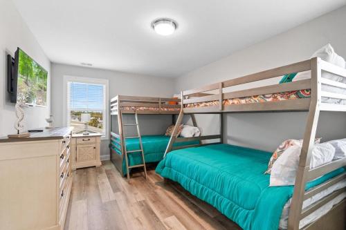 a bedroom with two bunk beds and a desk at It's Nautical Nonsense Oceanview 4 bedroom, 4 bath in Pawleys Island