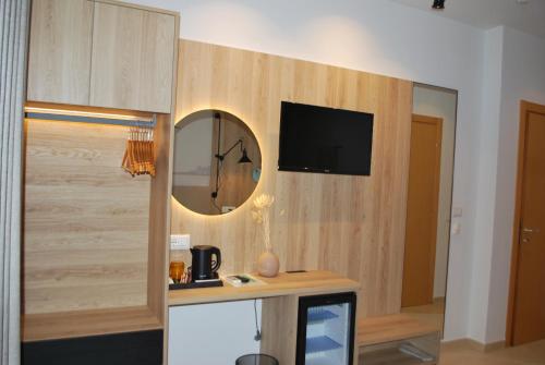 a room with a mirror and a tv on a wall at Sofo Hotel Dhermi in Dhërmi
