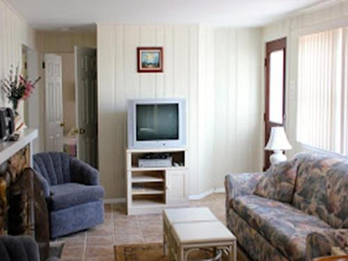 Una sala de estar con un sofá y un televisor. en Ocean Block Internetwifi Deck Washer & Dryer Well-Maintained First Floor Unit Of An Ocean Block Duplex Great Location, Just One House Between, en Peahala Park
