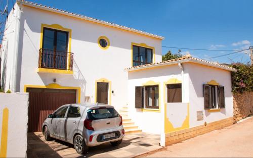 a car parked in front of a white house at Casa Bellarosa in Raposeira