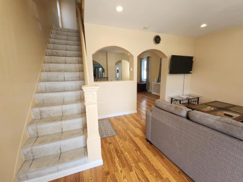 a living room with a staircase and a couch at The Delancy House-Near the Bay, Casinos &Boardwalk in Atlantic City