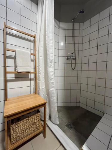 a bathroom with a shower with a bench and a shower curtain at Mosaikon Guesthouses #Vasilikis Str in Athens