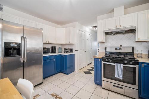 una cucina con elettrodomestici in acciaio inossidabile e armadi blu di Sands Retreat-Cozy!Close to Ocean Casino & Beach! ad Atlantic City