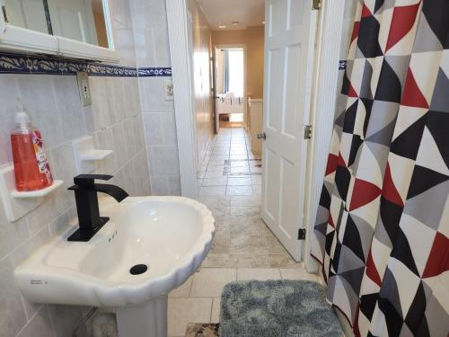 a bathroom with a sink and a tile floor at The Delancy House-Near the Bay, Casinos &Boardwalk in Atlantic City