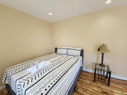a bedroom with a bed with white sheets and a lamp at The Delancy House-Near the Bay, Casinos &Boardwalk in Atlantic City