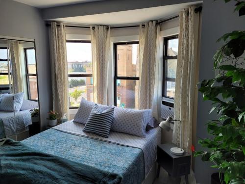 una camera da letto con un letto e due finestre di The Crows Nest-Lux Penthouse Escape, City views ad Atlantic City