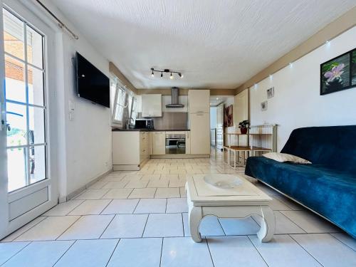 un salon avec un canapé bleu et une table dans l'établissement Appartement 4 personnes piscine calme, à Fréjus