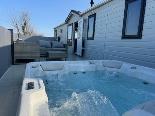 a hot tub in the backyard of a house at Golden Palm Resort - Sequoia Palm - Coastal Caravan Breaks in Chapel Saint Leonards
