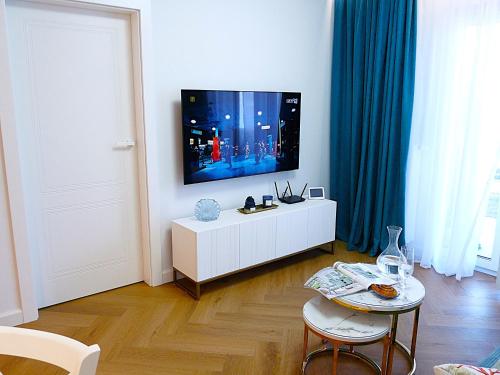 a living room with a tv on a white cabinet at Bursztynowy Brzeg - Mechelinki Revital in Mechelinki