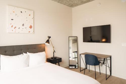 a bedroom with a bed and a desk and a tv at Kasa River North Chicago in Chicago