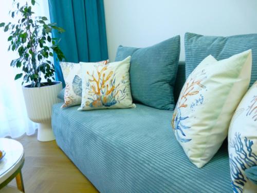 a blue couch with pillows on it in a living room at Bursztynowy Brzeg - Mechelinki Revital in Mechelinki