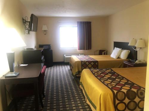 a hotel room with two beds and a desk at Hotel 7 Inn Vienna in Vienna