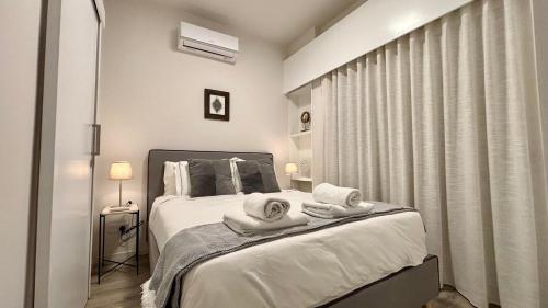 a bedroom with a bed with towels on it at SeaBreeze City Center Flats by TrulyCyprus in Limassol
