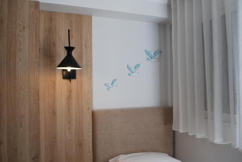 a bedroom with a bed with butterflies on the wall at Sofo Hotel Dhermi in Dhërmi