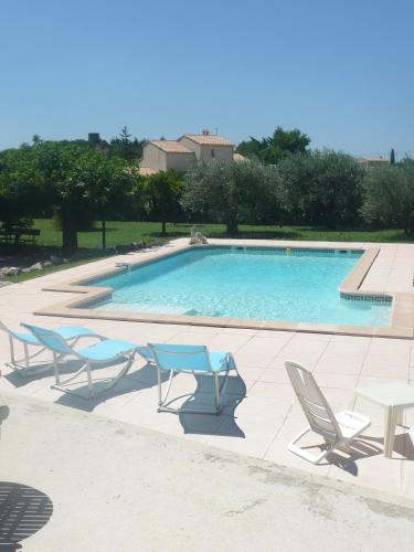 une piscine avec des chaises longues et une table dans l'établissement Jacambra, à Lédenon
