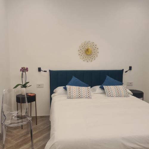a bedroom with a large white bed with blue accents at Tenuta Rispoli Amalfi vacationhouse in Amalfi