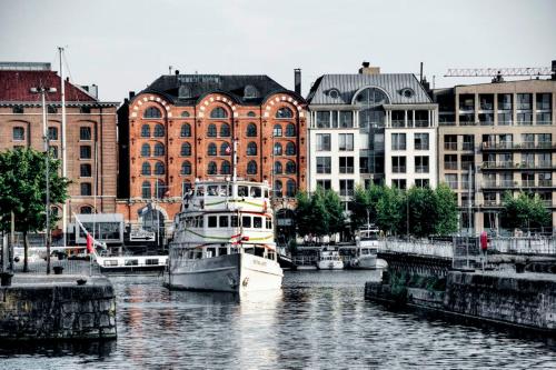 a boat is docked in the water in front of buildings at Radisson Blu Hotel, Antwerp City Centre in Antwerp