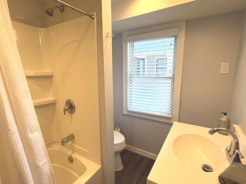 a bathroom with a sink and a tub and a toilet at The Beacon Ocean City- 7 Bedrooms, Close to All! in Ocean City