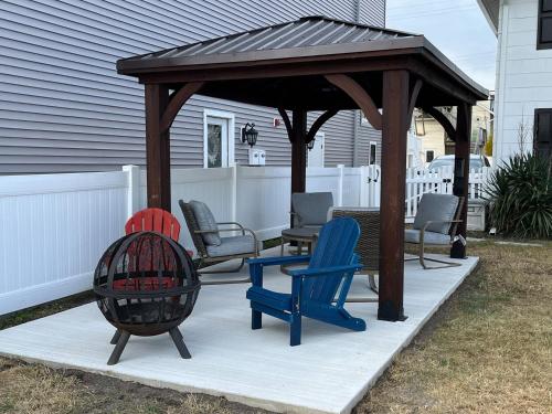 a wooden gazebo with chairs on a patio at The Beacon Ocean City- 7 Bedrooms, Close to All! in Ocean City
