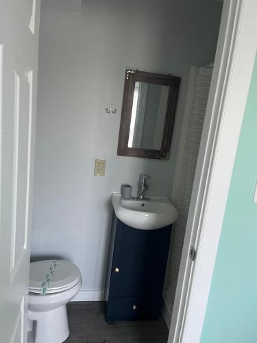 a bathroom with a sink and a toilet and a mirror at The Beacon Ocean City- 7 Bedrooms, Close to All! in Ocean City