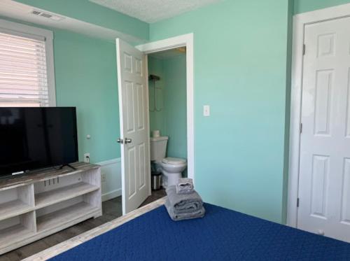a blue room with a toilet and a television at The Beacon Ocean City- 7 Bedrooms, Close to All! in Ocean City