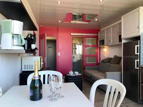 - une bouteille de vin assise sur une table dans la cuisine dans l'établissement Résidence Héliopolis Bâtiment Ab - Studio Cabine 2 pers- Héliopolis Bât. AB MAE-7211, au Cap d'Agde