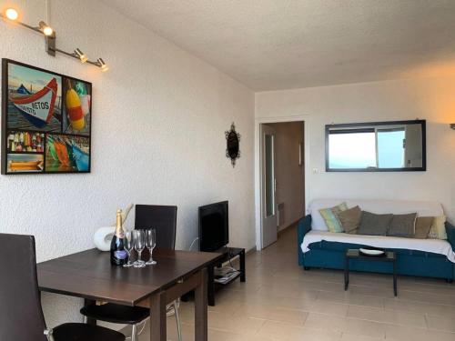 un salon avec un canapé et une table dans l'établissement Résidence Héliopolis Bâtiment Ab - Studio Cabine 4 pers- Héliopolis AB MAE-4434, au Cap d'Agde