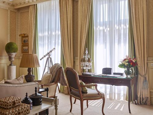 a living room with a desk and a chair and a couch at Grand Hotel Wien in Vienna