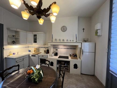 une cuisine avec une table et une cuisine avec des appareils électroménagers blancs dans l'établissement Résidence 027-soulac Sur Mer - 027 - Jolie Soulacaise en plein cœur de la Station MAE-6891, à Soulac-sur-Mer