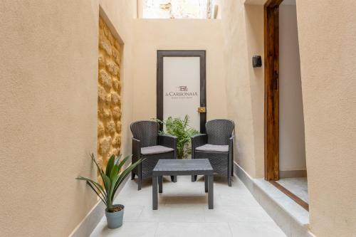 a hallway with chairs and a table and a mirror at La carbonaia rooms in Agrigento in Agrigento