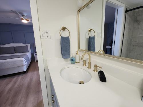 a bathroom with a sink with a mirror and a bed at Blue Lagoon - Near the Boardwalk & Casinos! in Atlantic City