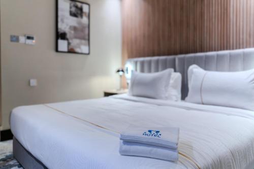 a white bed with a hotel sign on it at فندق هيل Hill Hotel in Al Madinah