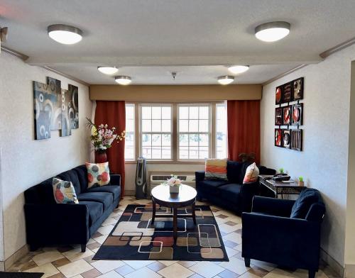 a living room with couches and a table at Super 8 by Wyndham Maumee Perrysburg Toledo Area in Maumee