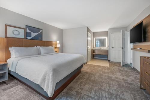 a bedroom with a bed and a flat screen tv at Staybridge Suites Rocklin - Roseville Area by IHG in Rocklin